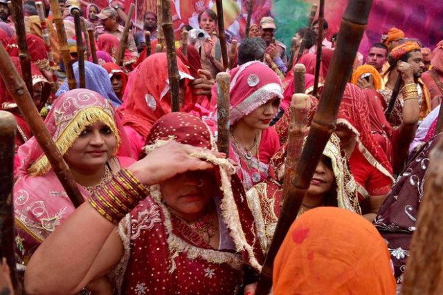 Devotees celebrate Latthmaar Holi at Dauji Temple